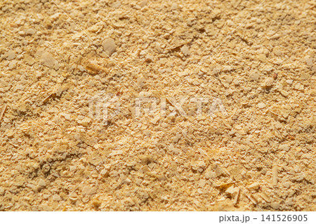 Close-up of nutritional yeast flakes texture on a flat surface, golden food seasoning background Close-up of nutritional yeast flakes texture on a flat surface, golden food seasoning background 141526905