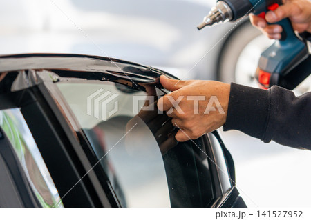 A car wrapping specialist applies a polyurethane film to the car. Detailer PPF 141527952