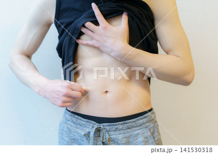 腹部を気にする若い日本人男性の手元のアップ 腹部を気にする若い日本人男性の手元のアップ 141530318