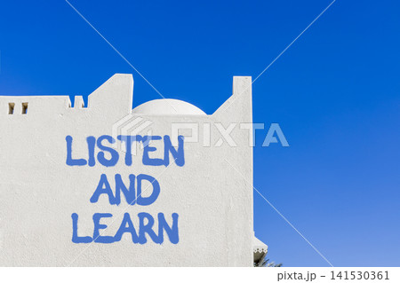 Listen and learn words symbol. Concept words Listen and learn on beautiful white wall. Beautiful blue sky background. Business listen and learn support concept. Copy space. 141530361