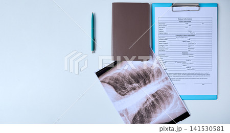 Chest X-ray and patient information form are placed on a table of medical clinic Chest X-ray and patient information form are placed on a table of medical clinic 141530581
