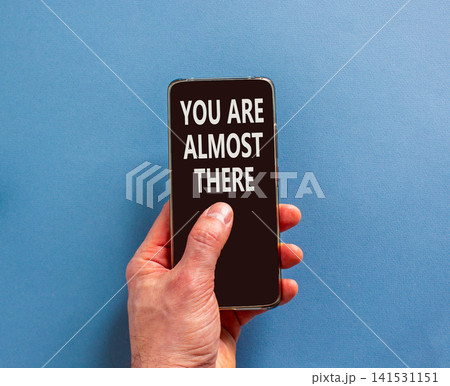 You are almost there words symbol. Concept words You are almost there on beautiful black phone screen. Beautiful blue background. Business You are almost there motivational support concept. Copy space 141531151