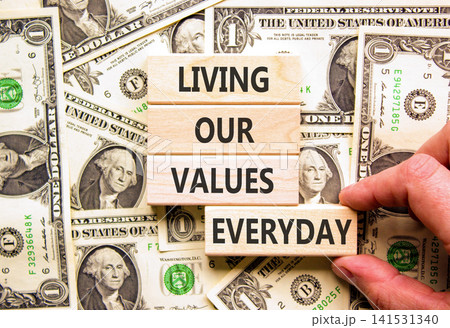 Living our values everyday words symbol. Concept words Living our values everyday on beautiful wooden blocks. Beautiful dollar bills background. Business living our values everyday concept. Copy space 141531340