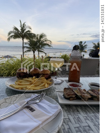 海の見える南国のカフェとワイングラスに入ったカクテル 海の見える南国のカフェとワイングラスに入ったカクテル 141531831