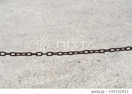 Rusty Metal Chain Across Concrete Surface Rusty Metal Chain Across Concrete Surface 141532051