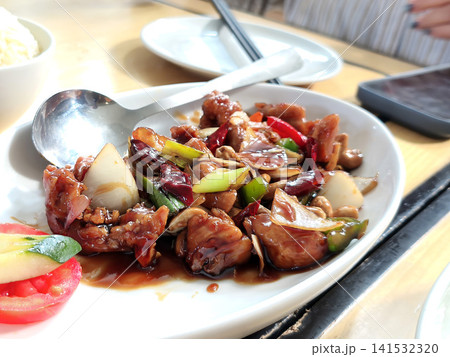 Close up top view of savory Kung Pao Chicken served over noodles or rice with rich sauce and fresh scallions. Close up top view of savory Kung Pao Chicken served over noodles or rice with rich sauce and fresh scallions. 141532320