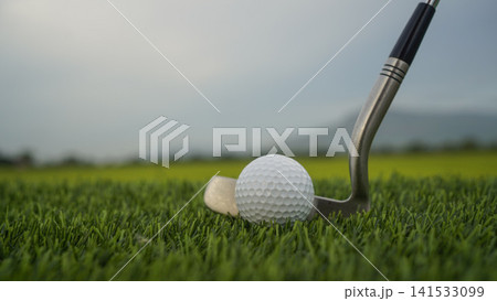Golf clubs and balls on a green lawn in a beautiful golf course with morning sunshine. 141533099