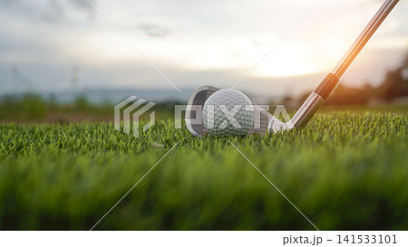 Golf clubs and balls on a green lawn in a beautiful golf course with morning sunshine. Golf clubs and balls on a green lawn in a beautiful golf course with morning sunshine. 141533101