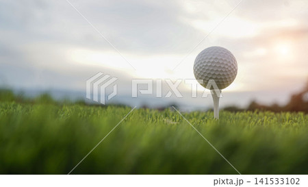 Golf ball on tee in a beautiful golf course with morning sunshine. Golf ball on tee in a beautiful golf course with morning sunshine. 141533102