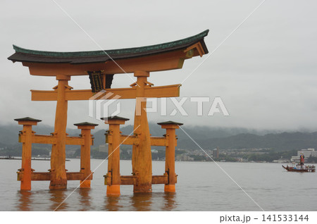 Itsukushima shrine red gate next to a boat for the Kangen-sai. Itsukushima shrine red gate next to a boat for the Kangen-sai. 141533144