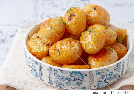 Baked new potatoes, with butter and dill, on a white plate, at home, no people, Baked new potatoes, with butter and dill, on a white plate, at home, no people, 141534474