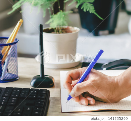 A man writes in a notebook and makes a business plan A man writes in a notebook and makes a business plan 141535299