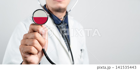Poland healthcare system, Polish national healthcare concept. Hand of doctor holding stethoscope Poland healthcare system, Polish national healthcare concept. Hand of doctor holding stethoscope 141535443