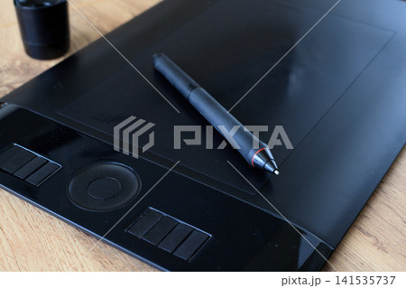 Digital stylus on a black graphics tablet for digital drawing. Digital illustration process and creativity 141535737