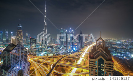 Modern skyscrapers and busy evening highways day to night timelapse in luxury Dubai city, Dubai, United Arab Emirates Modern skyscrapers and busy evening highways day to night timelapse in luxury Dubai city, Dubai, United Arab Emirates 141536127