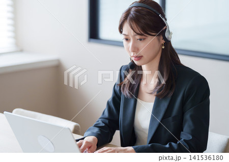 クレーム対応をするコールセンターの女性 クレーム対応をするコールセンターの女性 141536180