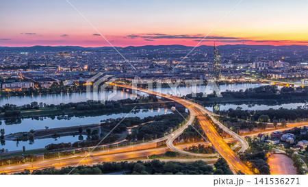 Aerial panoramic view over Vienna city with skyscrapers, historic buildings and a riverside promenade day to night timelapse in Austria. Aerial panoramic view over Vienna city with skyscrapers, historic buildings and a riverside promenade day to night timelapse in Austria. 141536271