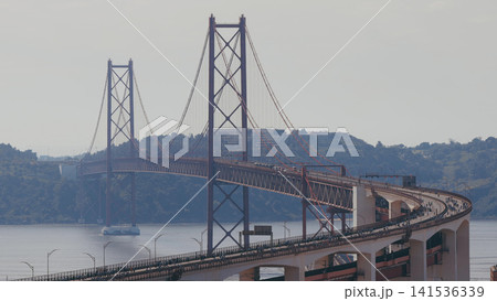 Running Lisbon half marathon crossing the 25 of April bridge over the Tagus river aerial view from above. Running Lisbon half marathon crossing the 25 of April bridge over the Tagus river aerial view from above. 141536339