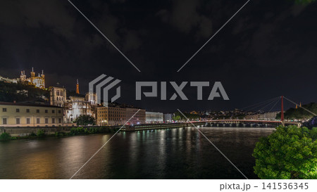 Panorama showing night timelapse of Lyon's cityscape with the red suspension footbridge over the Saone River. France Panorama showing night timelapse of Lyon's cityscape with the red suspension footbridge over the Saone River. France 141536345