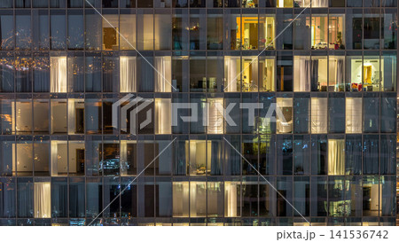 Windows of the multi-storey building of glass and steel lighting inside and moving people within timelapse Windows of the multi-storey building of glass and steel lighting inside and moving people within timelapse 141536742