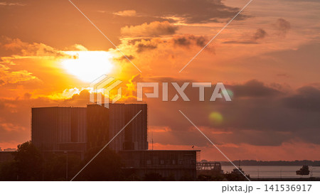 Beautiful sunrise at Marina Barrage timelapse. Orange sky and clouds with sun beams. Beautiful sunrise at Marina Barrage timelapse. Orange sky and clouds with sun beams. 141536917