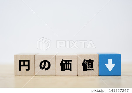円の価値下落。円安を示す下矢印のイメージ。木製ブロック 円の価値下落。円安を示す下矢印のイメージ。木製ブロック 141537247