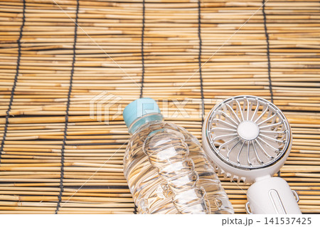 水と携帯扇風機を組み合わせた健康を意識する夏の構図 141537425