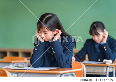 学校の教室・塾で試験・テストを受ける高校生・中学生・小学生の女の子(受験) 学校の教室・塾で試験・テストを受ける高校生・中学生・小学生の女の子(受験) 141537719