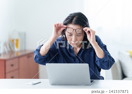 老眼鏡をかけてパソコンを使う中高年女性 141537871