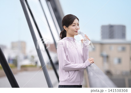 ウォーキング中にペットボトルの水を飲むミドル女性 141538308