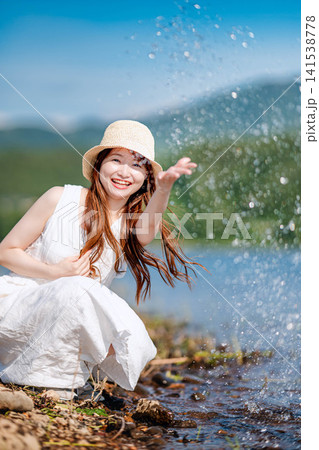 湖畔で水しぶきを上げて笑う女性 湖畔で水しぶきを上げて笑う女性 141538778