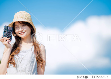 夏空を背景に佇む麦わら帽子の女性 夏空を背景に佇む麦わら帽子の女性 141538807