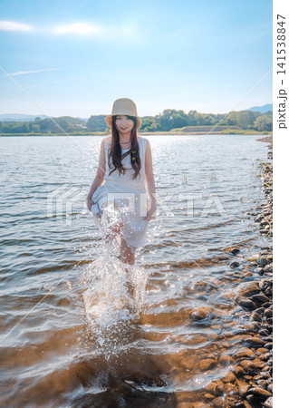 湖の中で水しぶきを上げる白ワンピースの女性 141538847