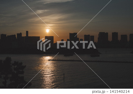 お台場の水辺に沈む夕日と都市のシルエット お台場の水辺に沈む夕日と都市のシルエット 141540214