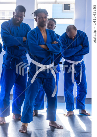 African american men in gis standing confidently on mats at martial arts studio African american men in gis standing confidently on mats at martial arts studio 141543268