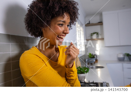 African american woman leaning on backsplash and laughing in kitchen, copy space 141543700
