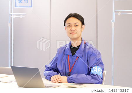 イベント受付で来場者を迎える男性スタッフ 141543817