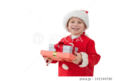 Schoolboy wearing Santa coat and hat, holding red and silver gifts in studio, copy space Schoolboy wearing Santa coat and hat, holding red and silver gifts in studio, copy space 141544780