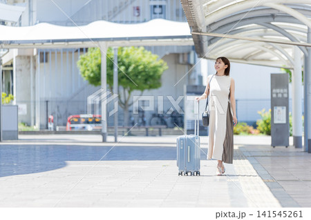 キャリーバッグを持って駅を歩く女性 キャリーバッグを持って駅を歩く女性 141545261