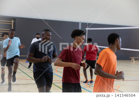 African American adolescent males in shorts running drills through orange rings, ladders in gym 141546504