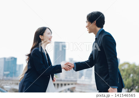 ビジネスの挨拶で握手をする女性と男性 ビジネスの挨拶で握手をする女性と男性 141546565
