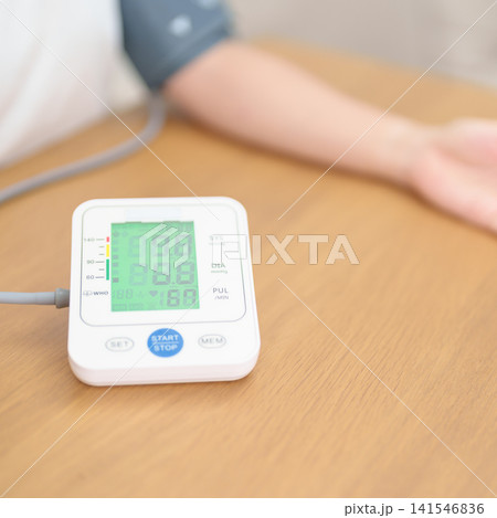 woman checking Blood pressure by Blood pressure monitor with Cuff. Systolic, SYS, Diastolic, DIA, Pulse, Hypertension, Hypotension, Heart rate, Cardiovascular Disease and May World hypertension day 141546836