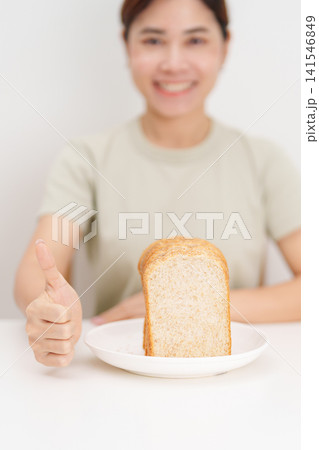 Happy smiling woman with whole wheat bread and thumbs up gesture. Weight loss, Dieting, Healthy eating, Calorie control, Fitness food, High fiber, Wellness, Lifestyle, Metabolism and Glycemic Index Happy smiling woman with whole wheat bread and thumbs up gesture. Weight loss, Dieting, Healthy eating, Calorie control, Fitness food, High fiber, Wellness, Lifestyle, Metabolism and Glycemic Index 141546849