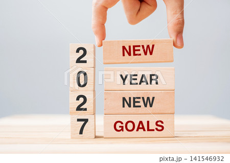 hand holding wooden block with text 2027 NEW YEAR NEW GOALS on table background. Resolution, strategy, solution, business and holiday concepts 141546932