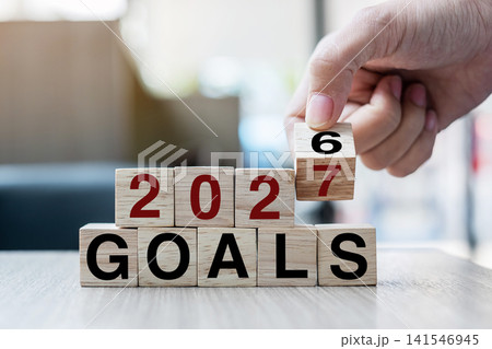 Businessman hand holding wooden cube with flip over block 2026 to 2027 Plans word on table background. Resolution, strategy, solution, goal, business and New Year holiday concepts Businessman hand holding wooden cube with flip over block 2026 to 2027 Plans word on table background. Resolution, strategy, solution, goal, business and New Year holiday concepts 141546945