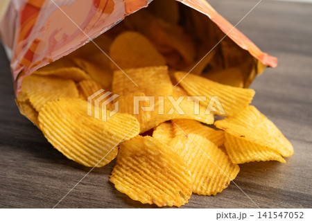 Potato chips delicious BBQ seasoning spicy for crips, thin slice deep fried snack fast food. Potato chips delicious BBQ seasoning spicy for crips, thin slice deep fried snack fast food. 141547052