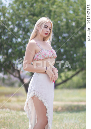 Outdoor fashion portrait of one adult woman shown in side profile in bright sunlight. Useful for summer clothing, beauty, elegance, and lifestyle concepts. Outdoor fashion portrait of one adult woman shown in side profile in bright sunlight. Useful for summer clothing, beauty, elegance, and lifestyle concepts. 141547178