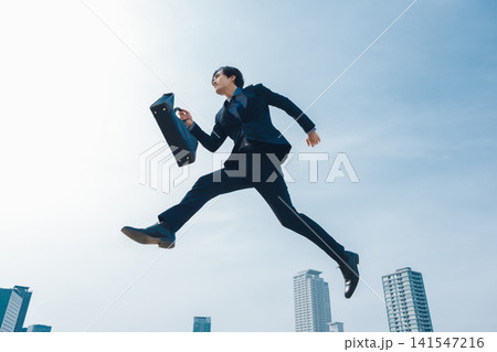 青空を背景にジャンプをするビジネスマン 141547216