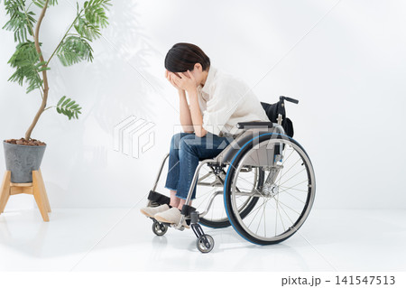 車椅子に乗る落ち込む女性 141547513