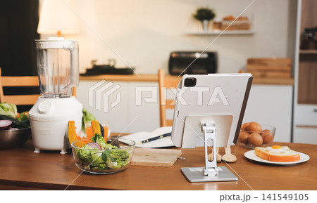 Woman preparing green smoothie in bright kitchen with fresh fruits and vegetables, healthy eating lifestyle moment in natural daylight Woman preparing green smoothie in bright kitchen with fresh fruits and vegetables, healthy eating lifestyle moment in natural daylight 141549105